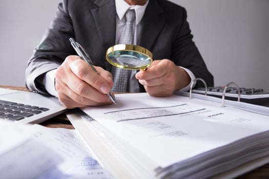 Checking Invoice with Magnifying Glass
