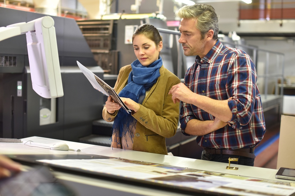 Man in printing house showing client printed documents.jpeg